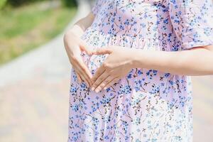 le Enceinte fille sur marcher dans ville parc photo