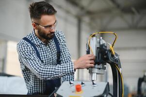 ouvrier dans uniforme travail sur machine dans pvc magasin intérieur photo