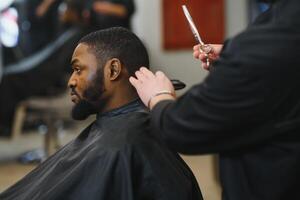 Jeune Afro-américain homme visite salon de coiffure photo