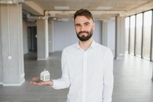 Masculin réel biens agent avec clé dans chambre. bannière pour conception photo