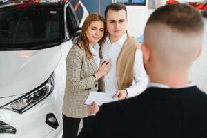 Jeune couple en utilisant une voiture dans une voiture salle d'exposition. photo