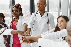 groupe de médecins en mettant mains ensemble dans clinique. unité concept. photo