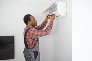 Jeune africain Masculin technicien réparer air Conditionneur photo