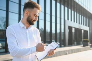 homme d'affaire ou réel biens agent prêt à discuter affaires et des stands contre Nouveau bâtiment photo