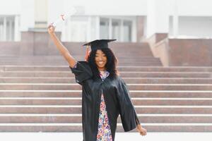 Joyeux étudiant diplômé afro-américain avec diplôme à la main photo