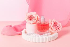 magnifique bouteille de parfum ou cosmétique vaporisateur, pot de visage peau se soucier crème sur blanc plâtre plateau avec des roses. produits de beauté et beauté concept. photo