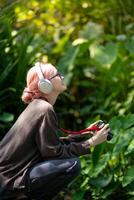 magnifique Jeune artiste femme prise photo dans fleurs jardin. Jeune mignonne fille porter le caméra dans le jardin