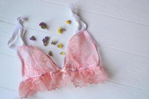 femme accessoires sur le en bois bureau. magnifique dentelle lingerie, fleurs et clou polonais. photo