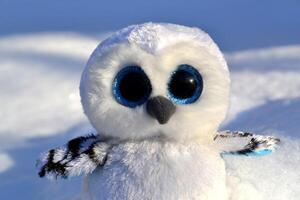 mignonne hibou jouet sur le neige Extérieur. photo