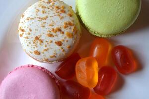 macarons et des sucreries dans le blanc plaque. savoureux Contexte. photo