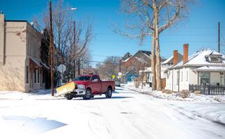 le rouge chasse-neige un camion clairière Frais neige de rue dans une Résidentiel zone photo