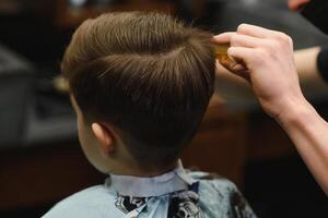 de bonne humeur caucasien garçon avoir coiffure dans salon de coiffure photo