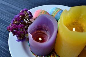 coloré Pâques des œufs avec fleurs et bougies dans le plaque. magnifique Pâques Contexte. Pâques carte. fait maison vacances décor. photo