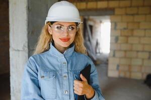 construction concept. jolie femelle constructeur dans salopette et casque travail sur construction placer. photo