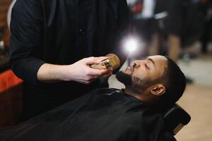 visite salon de coiffure. africain américain homme dans une élégant coiffeur magasin photo