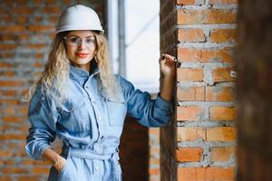 entrepôt femme ouvrier. femme constructeur dans casque. fille ingénieur ou architecte. Accueil rénovation. qualité inspecteur. construction emploi profession. construction ouvrier. Dame à construction placer. photo