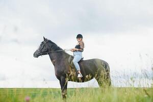 magnifique fille équitation une cheval dans campagne. photo