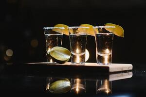 Tequila avec citron vert sur une foncé Contexte photo