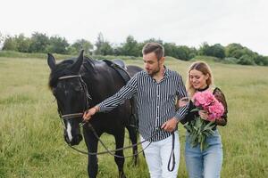 couple dans l'amour ayant amusement dans la nature. Jeune couple avec une cheval. photo