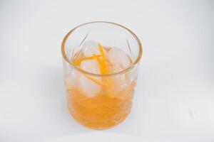 verre de boulevardier cocktail avec gros la glace cube et Orange zeste, classique cocktail arroser boulevardier avec Orange et Vermouth isolé sur blanc Contexte photo