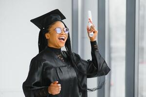 Joyeux étudiant diplômé afro-américain avec diplôme à la main photo