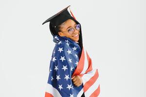 charmant femelle étudiant souriant dans lunettes portant noir manteau et permanent avec américain drapeau photo