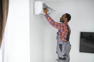 Jeune africain Masculin technicien réparer air Conditionneur photo