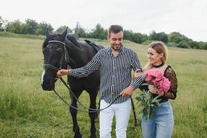 couple dans l'amour ayant amusement dans la nature. Jeune couple avec une cheval. photo