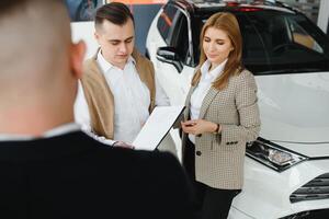 Jeune couple en utilisant une voiture dans une voiture salle d'exposition. photo