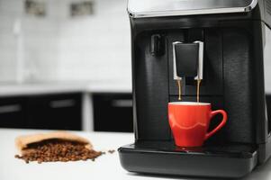 moderne Expresso café machine avec une tasse dans intérieur de cuisine fermer photo