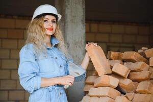 entrepôt femme ouvrier. femme constructeur dans casque. fille ingénieur ou architecte. Accueil rénovation. qualité inspecteur. construction emploi profession. construction ouvrier. Dame à construction site photo