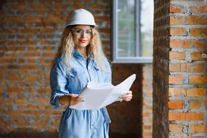 beau femme ingénieur est révision le des plans de une construction travail photo