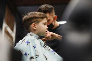 de bonne humeur caucasien garçon avoir coiffure dans salon de coiffure photo