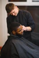 Jeune Afro-américain homme visite salon de coiffure photo