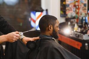 visite salon de coiffure. africain américain homme dans une élégant coiffeur magasin photo