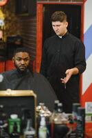 visite salon de coiffure. africain américain homme dans une élégant coiffeur magasin photo