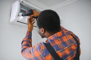 Jeune africain Masculin technicien réparer air Conditionneur photo