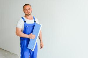 une homme processus le mur avec une spatule. plâtrier à travail. photo