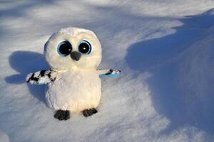 mignonne hibou jouet sur le neige Extérieur. photo