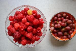 mûr framboises dans cristal bol sur le tableau. photo