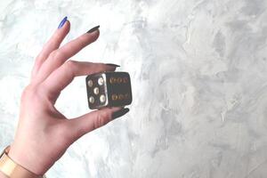 dé cube avec précieux bijoux femelle main. femme en portant jouer cube. photo