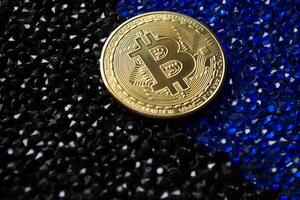 d'or bitcoin sur une noir et bleu strass. photo