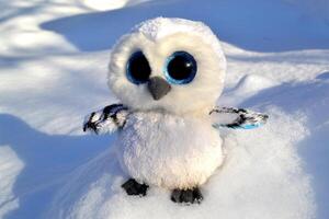 mignonne hibou jouet sur le neige Extérieur. photo