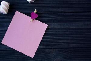 le feuille de rose papier, stylo et guimauve sur une foncé bleu en bois tableau. photo