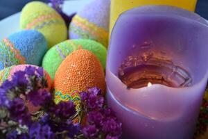 coloré Pâques des œufs avec fleurs et bougies dans le plaque. magnifique Pâques Contexte. Pâques carte. fait maison vacances décor. photo