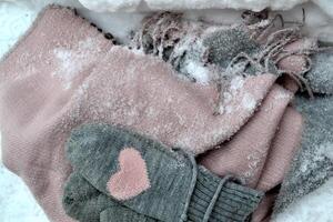 hiver de laine textile. écharpe et Mitaines sur le neige. magnifique hiver Contexte. du froid saison. photo