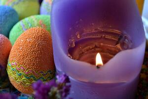 coloré Pâques des œufs avec fleurs et bougies dans le plaque. magnifique Pâques Contexte. Pâques carte. fait maison vacances décor. photo