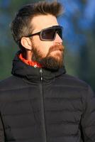 une Jeune homme avec barbe et des sports des lunettes photo