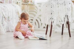 belle petite fille a lu un livre avec son ours préféré sur une douce couverture en peluche photo