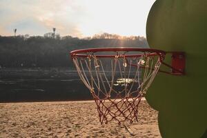 basketball sur le le coucher du soleil plage. basketball bague sur le plage. photo